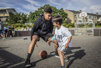 Ung dreng og barn spiller basket. Foto: Caroline Bohn