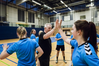 Træner giver håndboldspiller en high-five