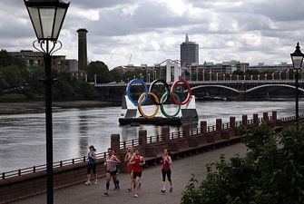 Løbere i London med OL ringe i baggrunden