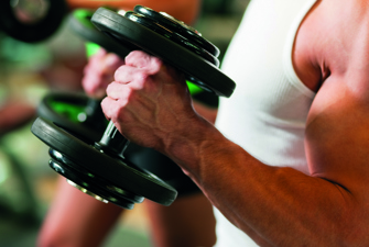 Person løfter håndvægte. Foto: Colourbox