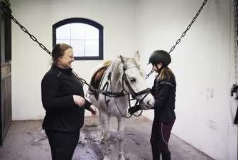Træner i ridning og rytter med hest