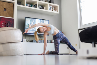 Kvinde dyrker fitness derhjemme