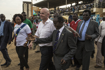 Infantino bliver ført ind på et stadion.