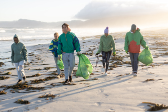 Folk der samler skrald på en strand