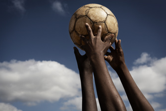 Hands touching football. Tine Harden