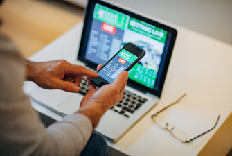 Mand med mobil og computer