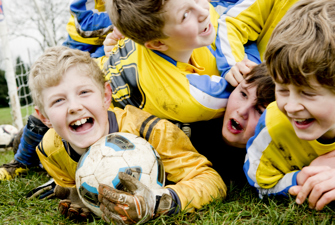 Kids lying down with a soccer ball